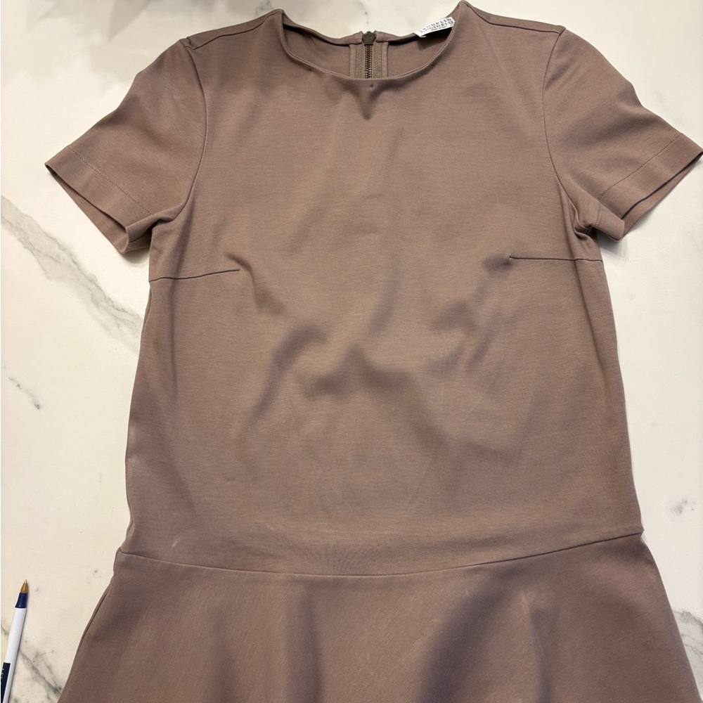 Brunello Cucinelli short sleeve top with peplum hem and back zipper.